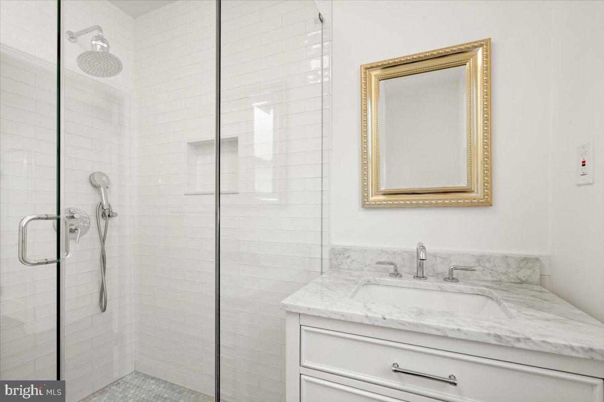 4302 30th Street Mount Rainier, MD 20712 - Photo 10 of 23 a bathroom with a granite countertop sink a mirror and shower