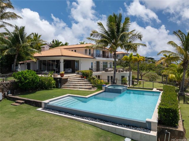 a view of a house with pool and chairs
