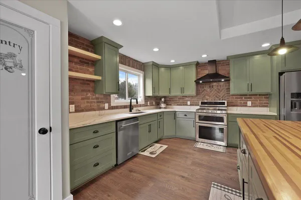a kitchen with stainless steel appliances kitchen island granite countertop a sink and cabinets