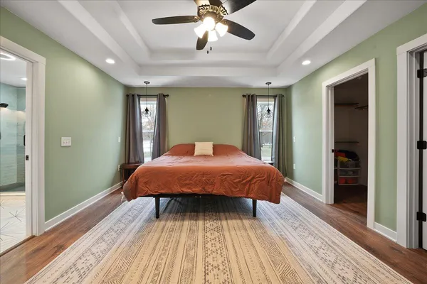 a spacious bathroom with a granite countertop sink a mirror and shower
