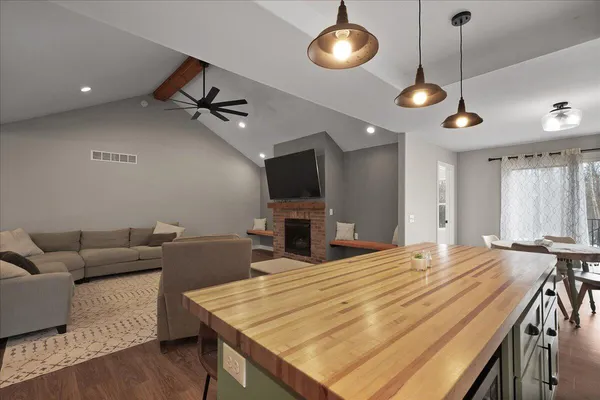 a living room with furniture a flat screen tv and a chandelier