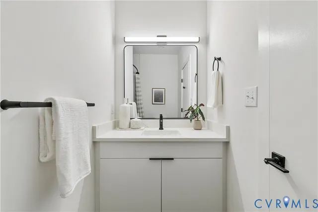 a bathroom with a sink vanity and a mirror