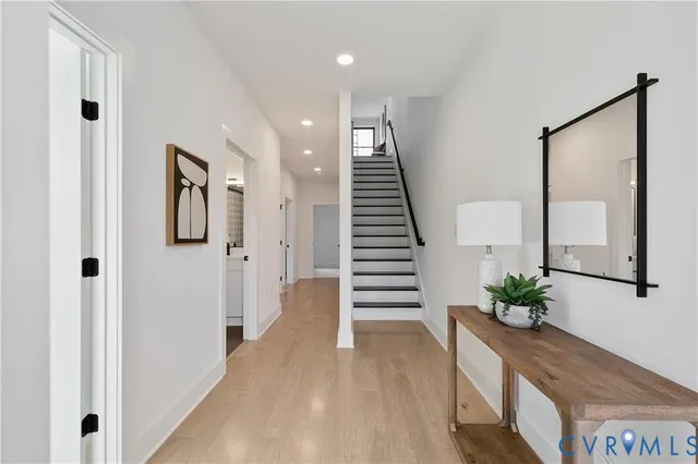 a view of a hallway with wooden floor and stairs