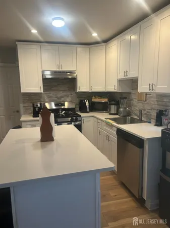 a kitchen with a sink a stove top oven and cabinets