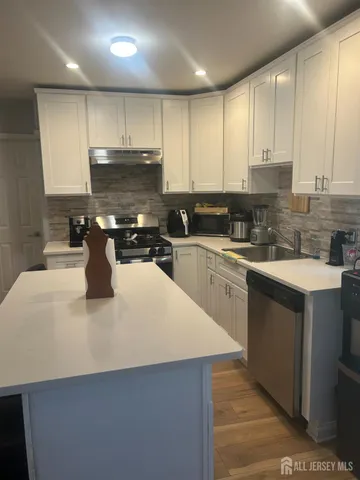 a kitchen with a sink a stove top oven and cabinets