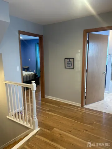 a view of a hallway with wooden floor and staircase