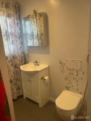 a bathroom with a sink a toilet and shower curtain