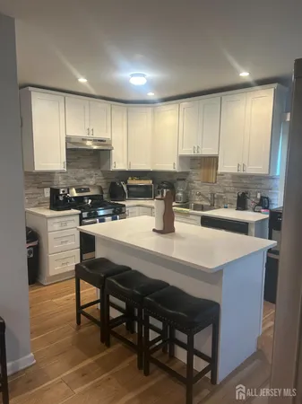 a kitchen with a dining table chairs and cabinets