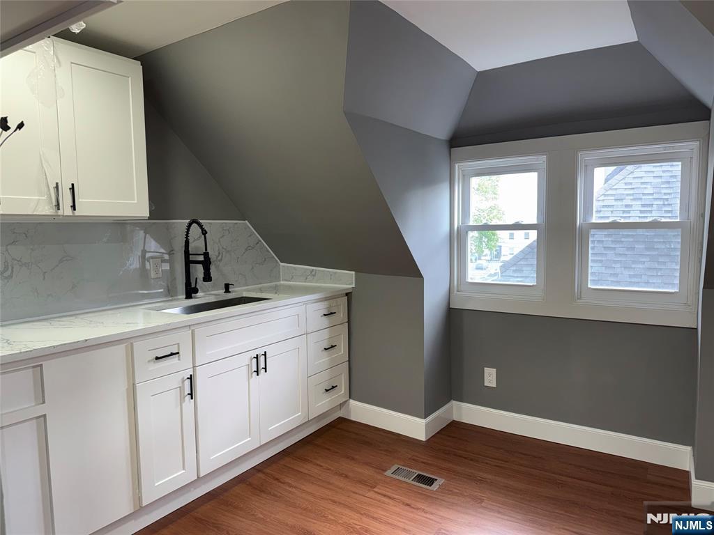 178 Berry Street Hackensack, NJ 07601 - Photo 15 of 22 a view of cabinets a wooden floor and windows in a kitchen