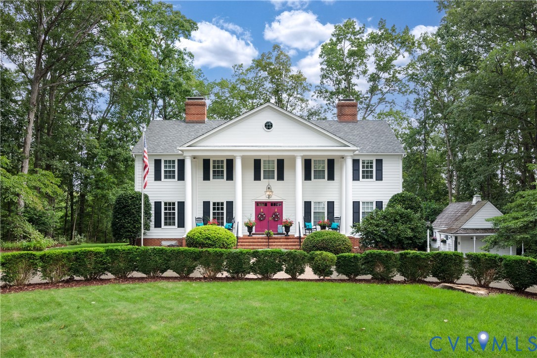 a front view of a house with a yard and green space