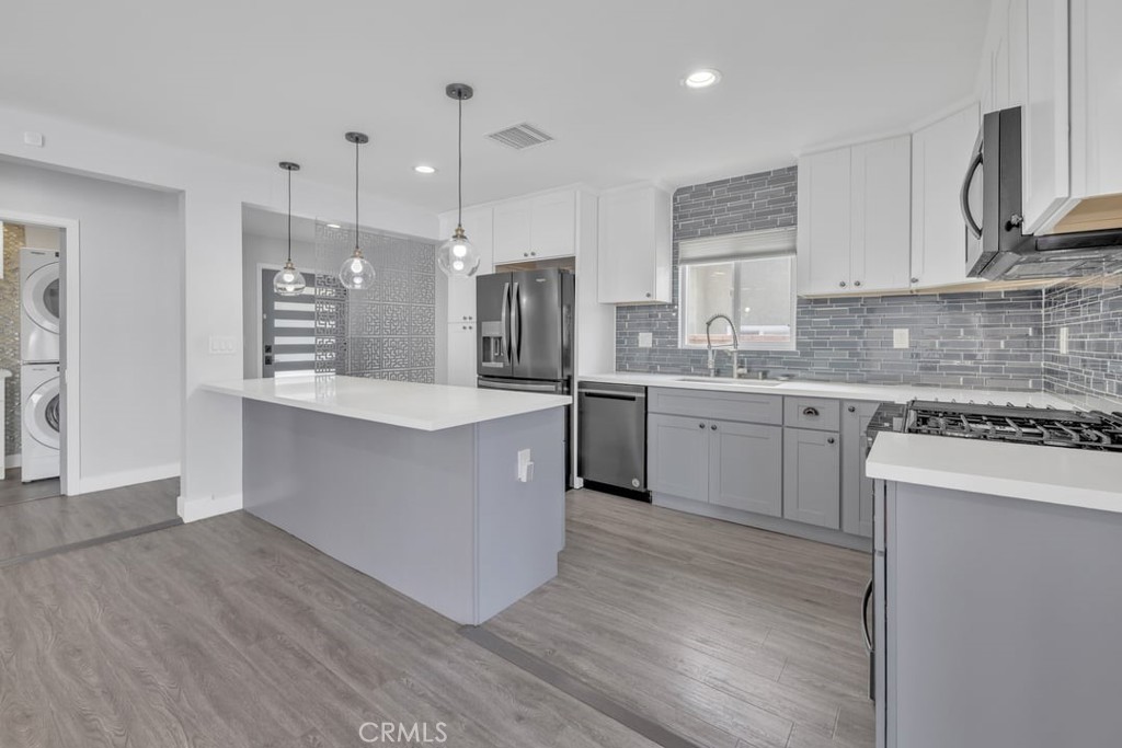 2909 Nipomo Avenue Long Beach, CA 90815 - Photo 7 of 41 a large kitchen with stainless steel appliances kitchen island a large counter top and a wooden floors