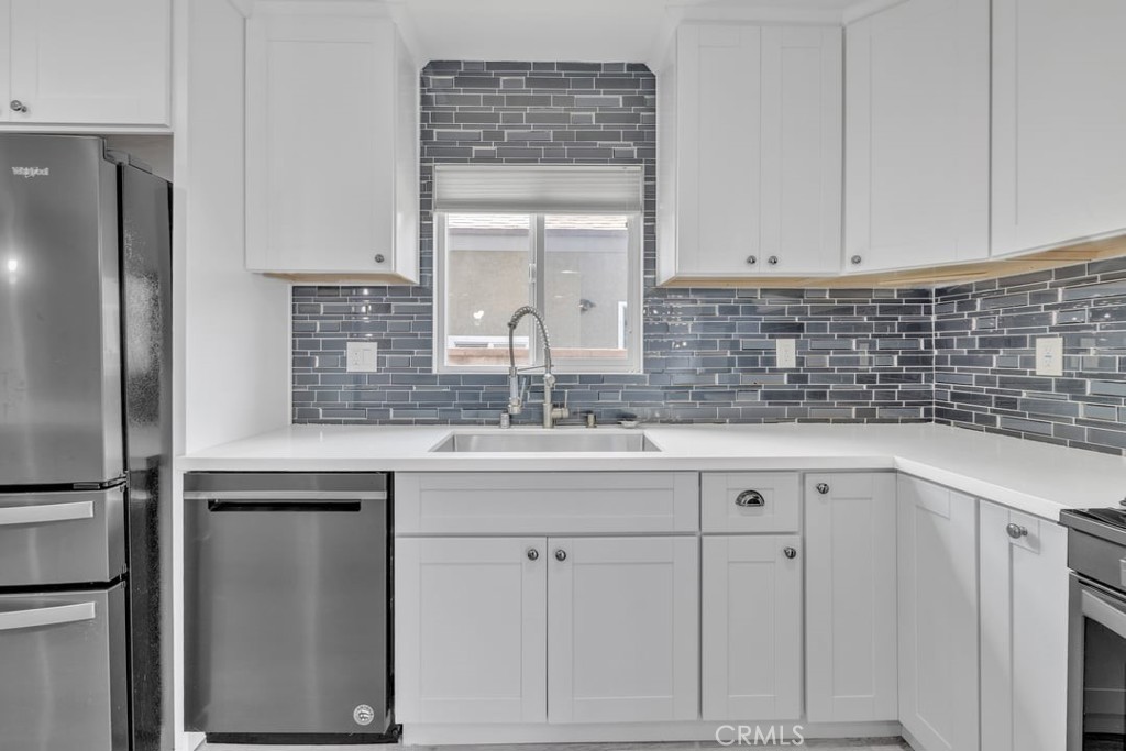 2909 Nipomo Avenue Long Beach, CA 90815 - Photo 8 of 41 a kitchen with white cabinets and refrigerator