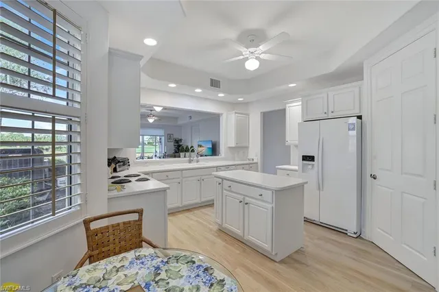 a kitchen with white cabinets and appliances
