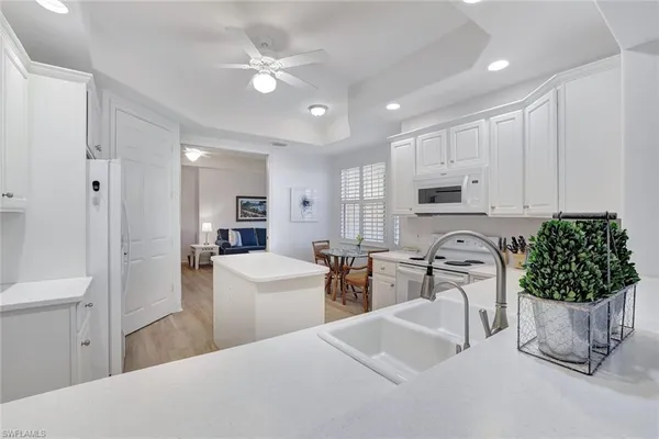 a living room with furniture a fireplace and a chandelier