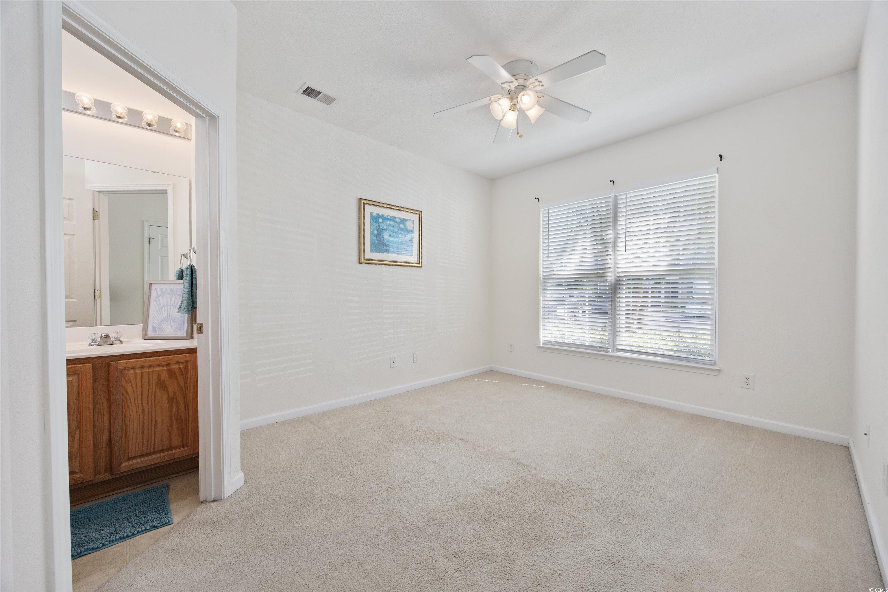 155 Chenoa Drive, Unit D Murrells Inlet, SC 29576 - Photo 13 of 33 Unfurnished bedroom with light colored carpet, connected bathroom, and a ceiling fan