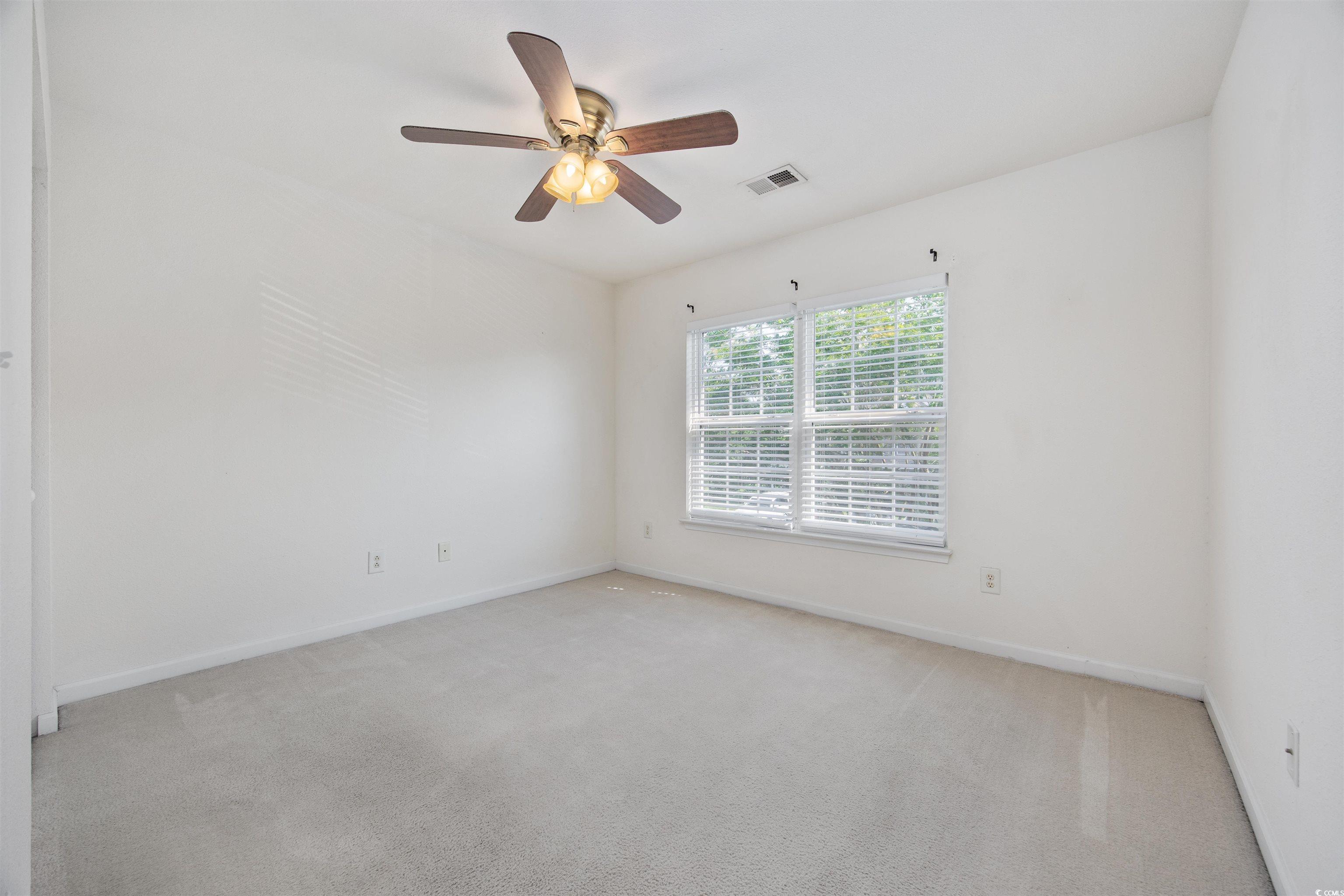 155 Chenoa Drive, Unit D Murrells Inlet, SC 29576 - Photo 15 of 33 Spare room featuring carpet and a ceiling fan