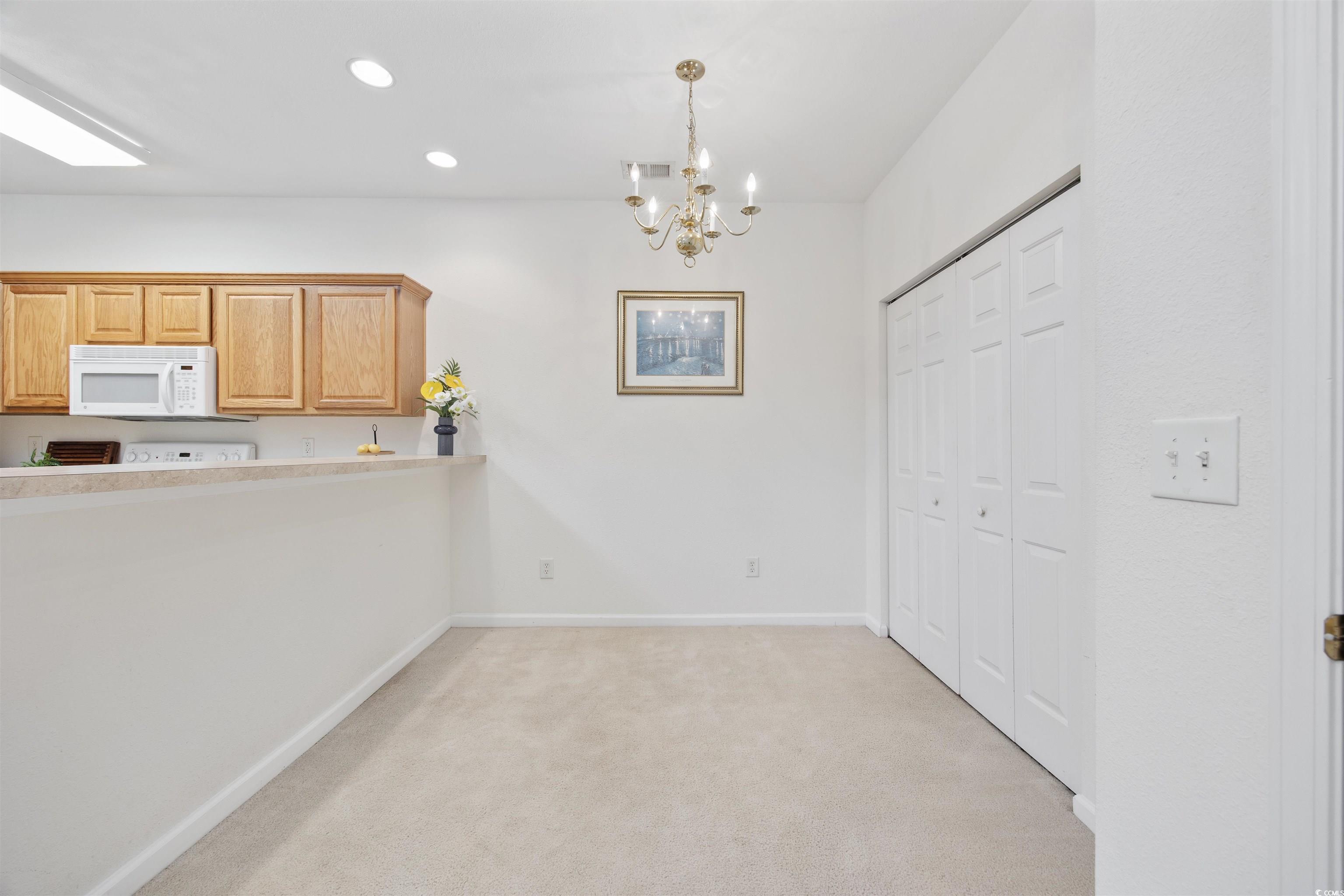 155 Chenoa Drive, Unit D Murrells Inlet, SC 29576 - Photo 8 of 33 Kitchen with white microwave, light carpet, a chandelier, light countertops, and recessed lighting