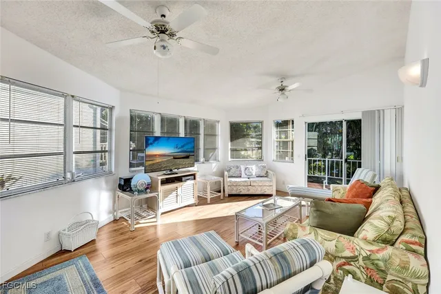 a living room with furniture ceiling fan and a window