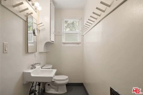 a bathroom with a sink a toilet and mirror