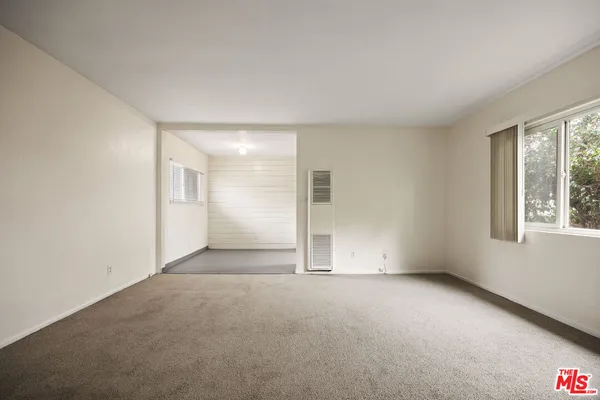 an empty room with windows and closet