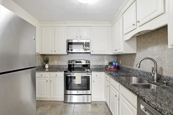 a kitchen with stainless steel appliances granite countertop a sink stove and cabinets