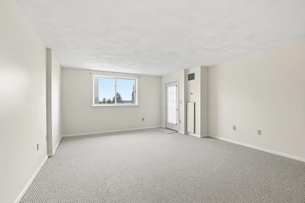 a view of empty room with kitchen