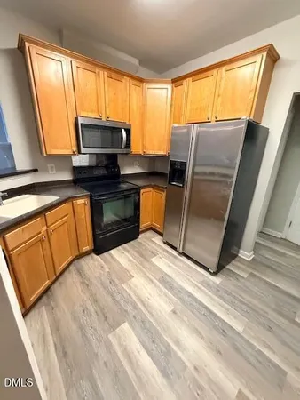 a kitchen with stainless steel appliances granite countertop sink microwave and window