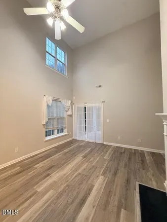 a view of empty room with fireplace and wooden floor