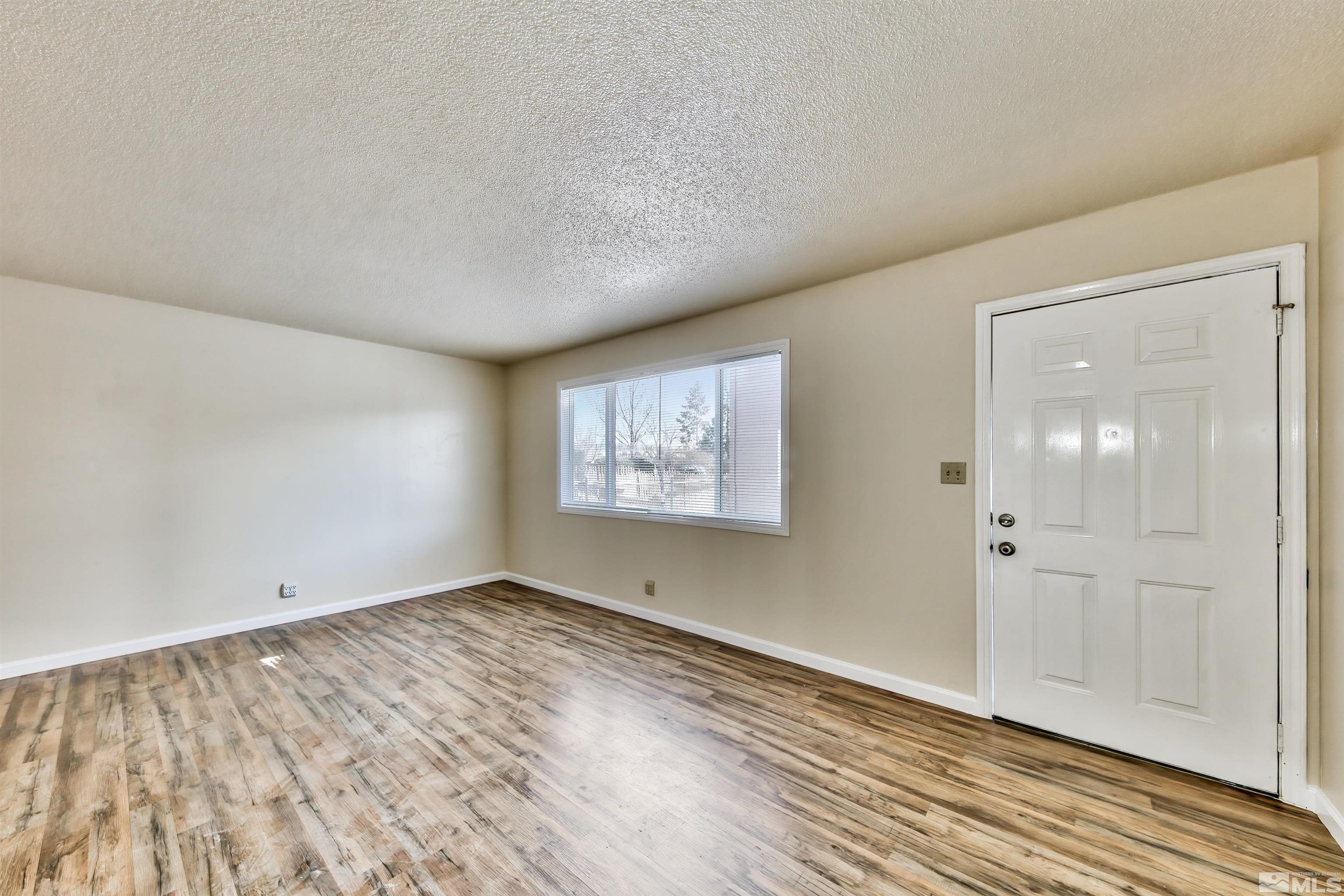 420 Lee Street Carson City, NV 89706 - Photo 11 of 29 an empty room with wooden floor and windows