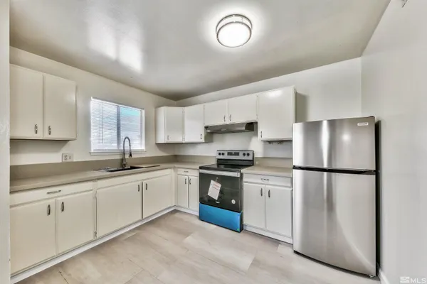 a kitchen with white cabinets and white appliances