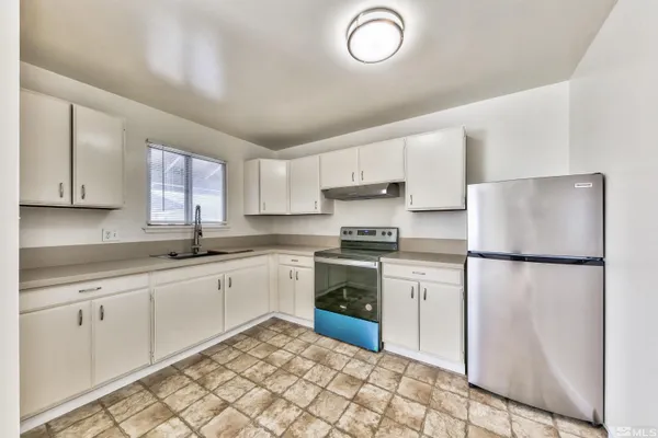 a kitchen with sink refrigerator and cabinets