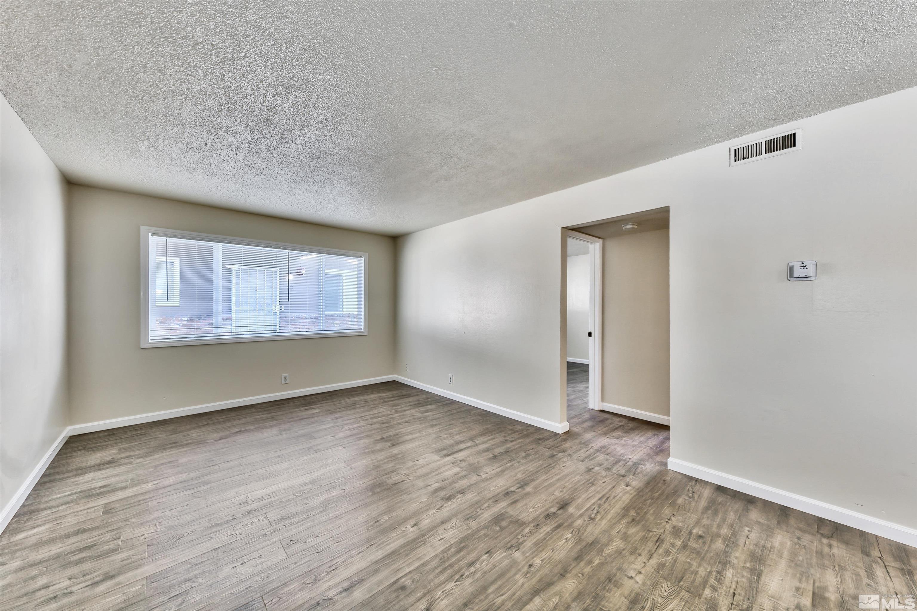 420 Lee Street Carson City, NV 89706 - Photo 20 of 29 a view of an empty room with wooden floor and a window