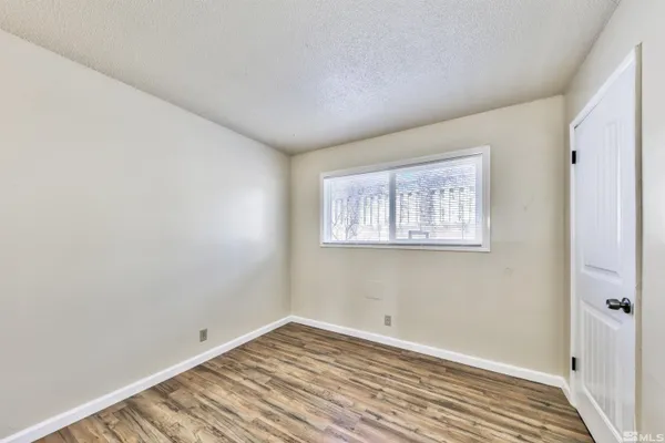 a view of a room with wooden floor and windows