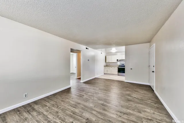 a view of empty room with wooden floor