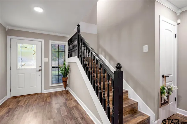 a view of a hallway with wooden floor and stairs