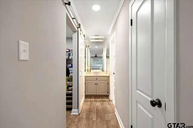 a view of a hallway with wooden floor and closet