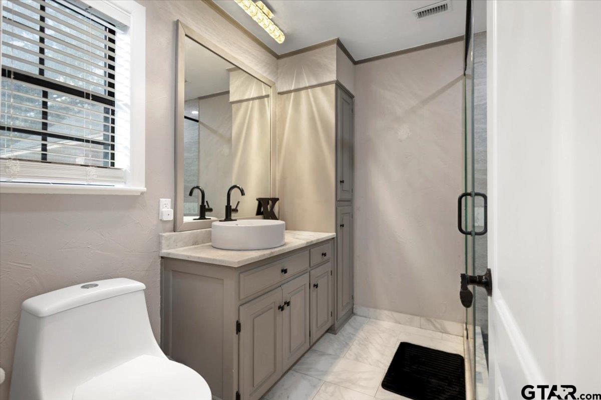 1701 Edgebrook Street Henderson, TX 75652 - Photo 18 of 36 a bathroom with a sink toilet and shower