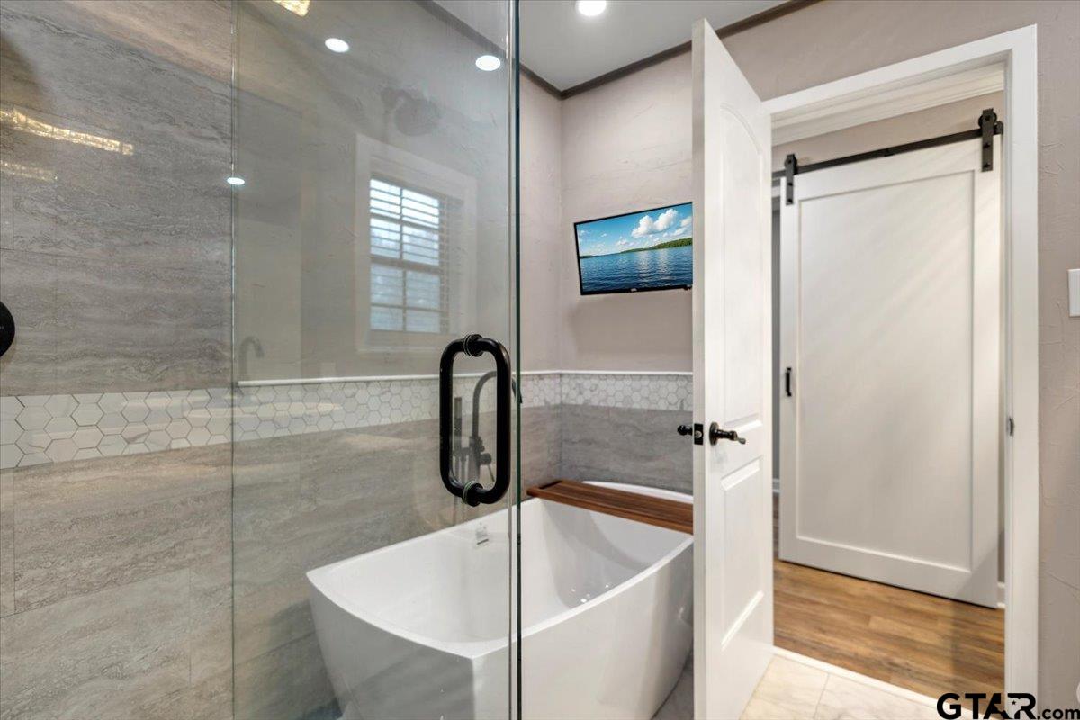 1701 Edgebrook Street Henderson, TX 75652 - Photo 19 of 36 a bathroom with a tub a mirror and a shower