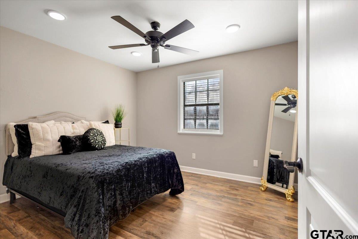 1701 Edgebrook Street Henderson, TX 75652 - Photo 24 of 36 a bedroom with a large bed and a chandelier