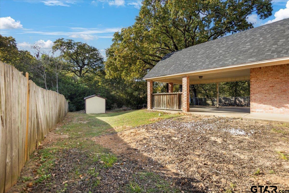 1701 Edgebrook Street Henderson, TX 75652 - Photo 28 of 36 a view of a house with backyard and a tree