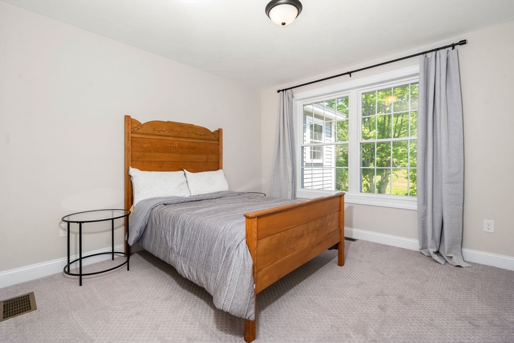 275 Chestnut Street Hudson, MA 01749 - Photo 18 of 34 a bed sitting in a room next to a window