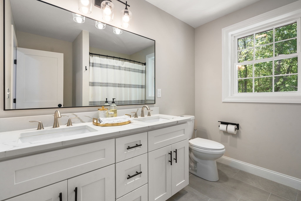 275 Chestnut Street Hudson, MA 01749 - Photo 20 of 34 a bathroom with a toilet sink and mirror