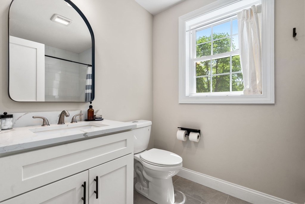 275 Chestnut Street Hudson, MA 01749 - Photo 23 of 34 a bathroom with a toilet a sink a vanity and mirror