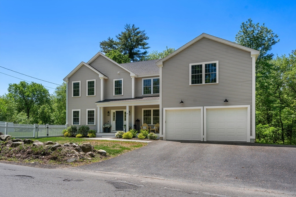 275 Chestnut Street Hudson, MA 01749 - Photo 26 of 34 a front view of a house with a yard and garage