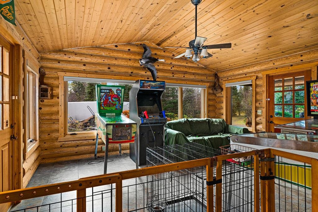 90190 Bark Point Road Herbster, WI 54844 - Photo 14 of 42 Tiled living room with rustic walls, vaulted ceiling, wood ceiling, and ceiling fan