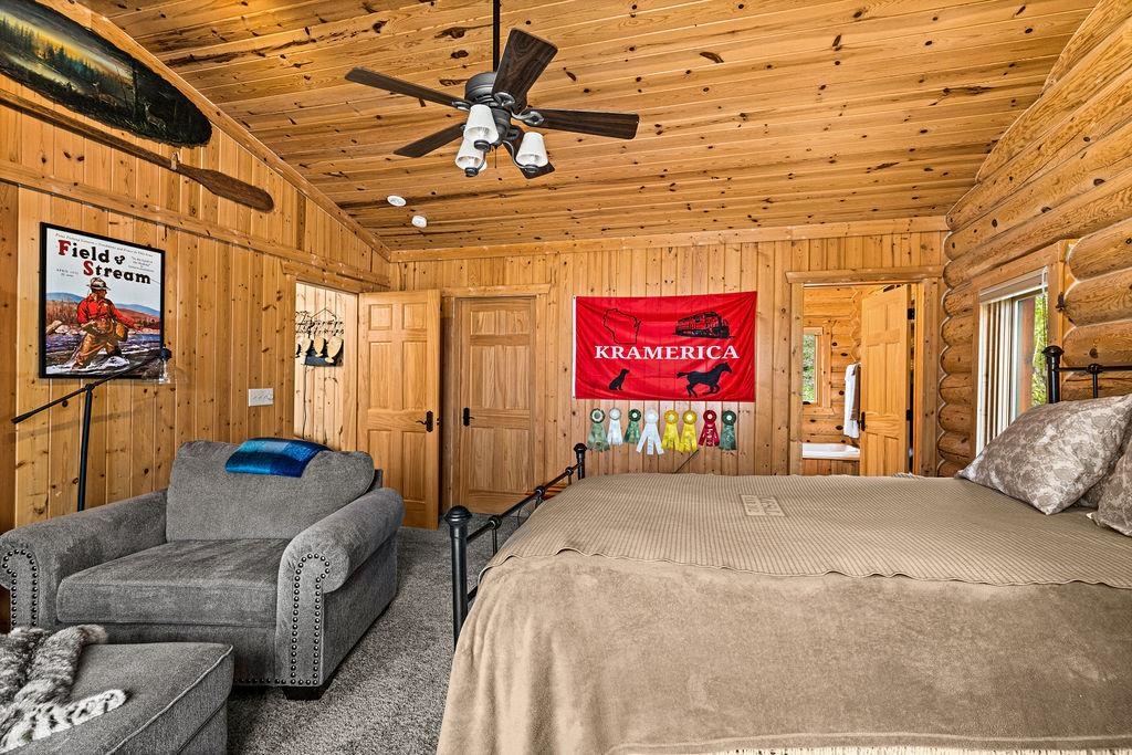 90190 Bark Point Road Herbster, WI 54844 - Photo 15 of 42 Carpeted bedroom with lofted ceiling, rustic walls, wood ceiling, and ensuite bath