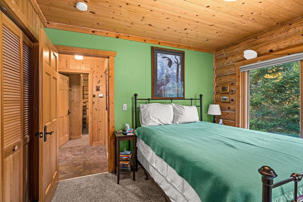 90190 Bark Point Road Herbster, WI 54844 - Photo 16 of 42 Carpeted bedroom with wood ceiling, a closet, and rustic walls