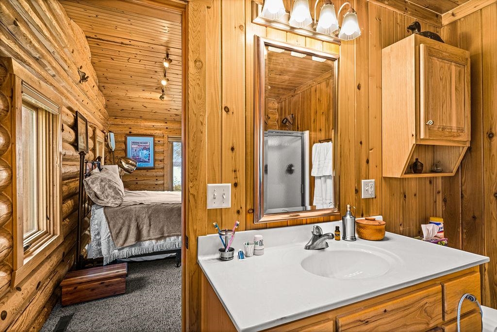 90190 Bark Point Road Herbster, WI 54844 - Photo 20 of 42 Full bath with connected bathroom, vanity, wooden ceiling, carpet, and log walls