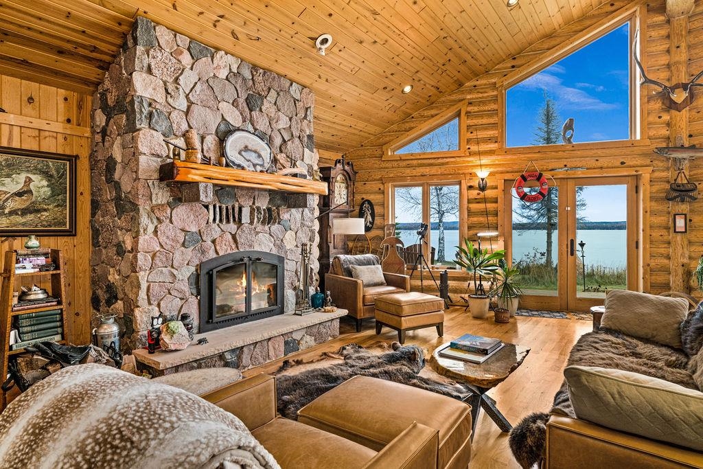 90190 Bark Point Road Herbster, WI 54844 - Photo 7 of 42 Living area featuring high vaulted ceiling, a stone fireplace, wood-type flooring, a water view, and french doors