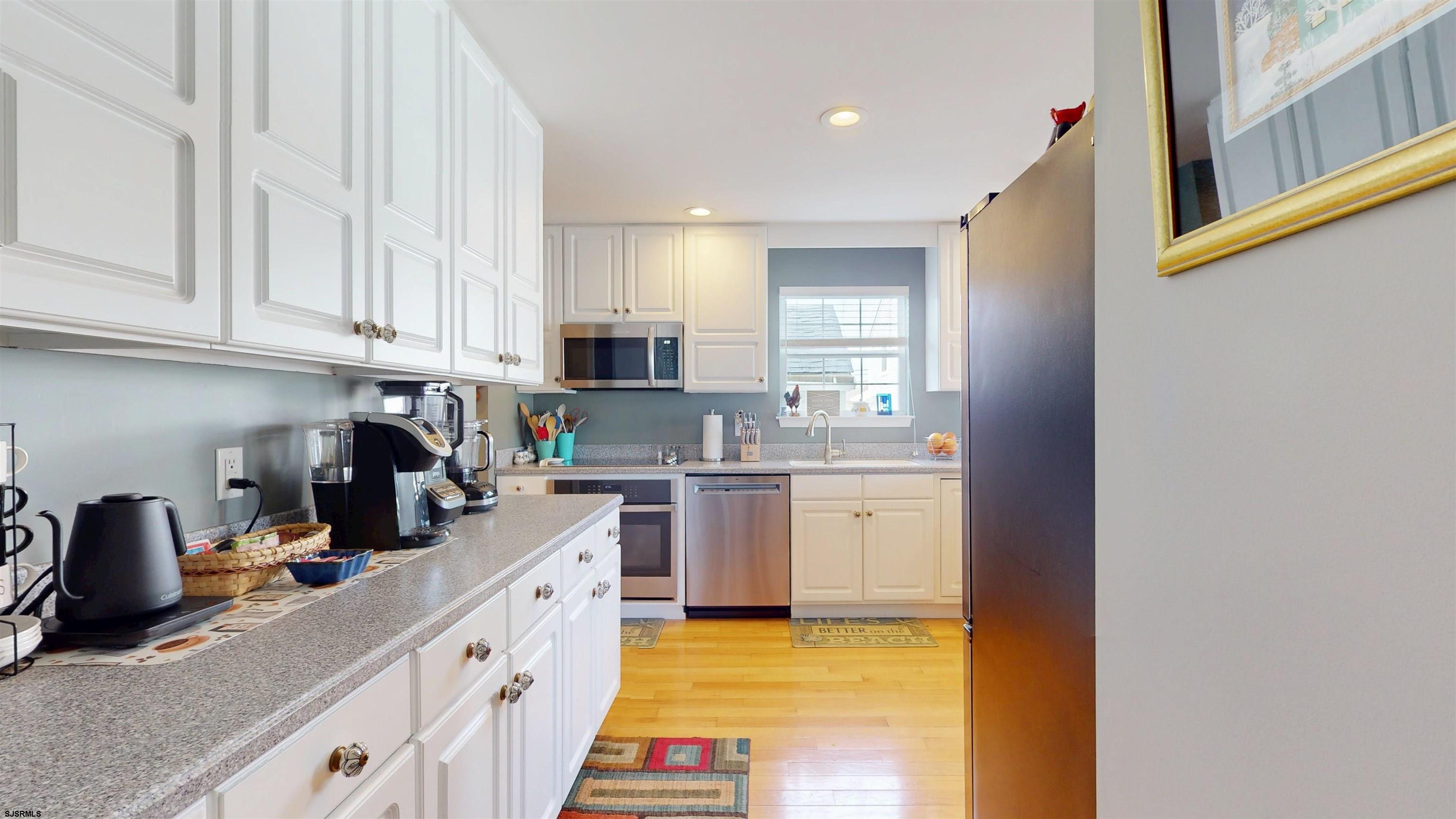 201 25th Street South Brigantine, NJ 08203 - Photo 16 of 60 a kitchen with kitchen island granite countertop a sink cabinets and window
